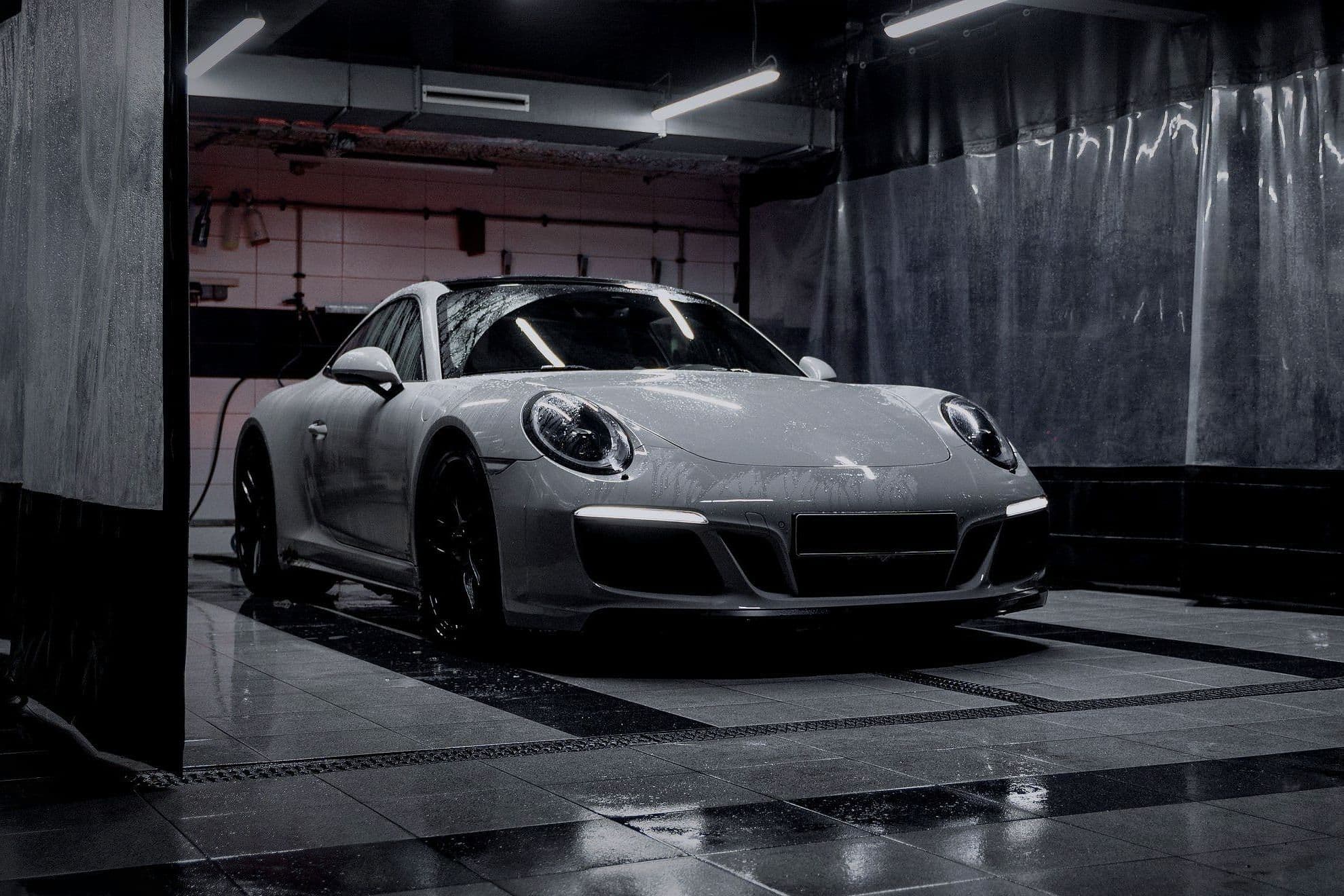 The silver-grey 911 in the preparation bay, front three-quarter.