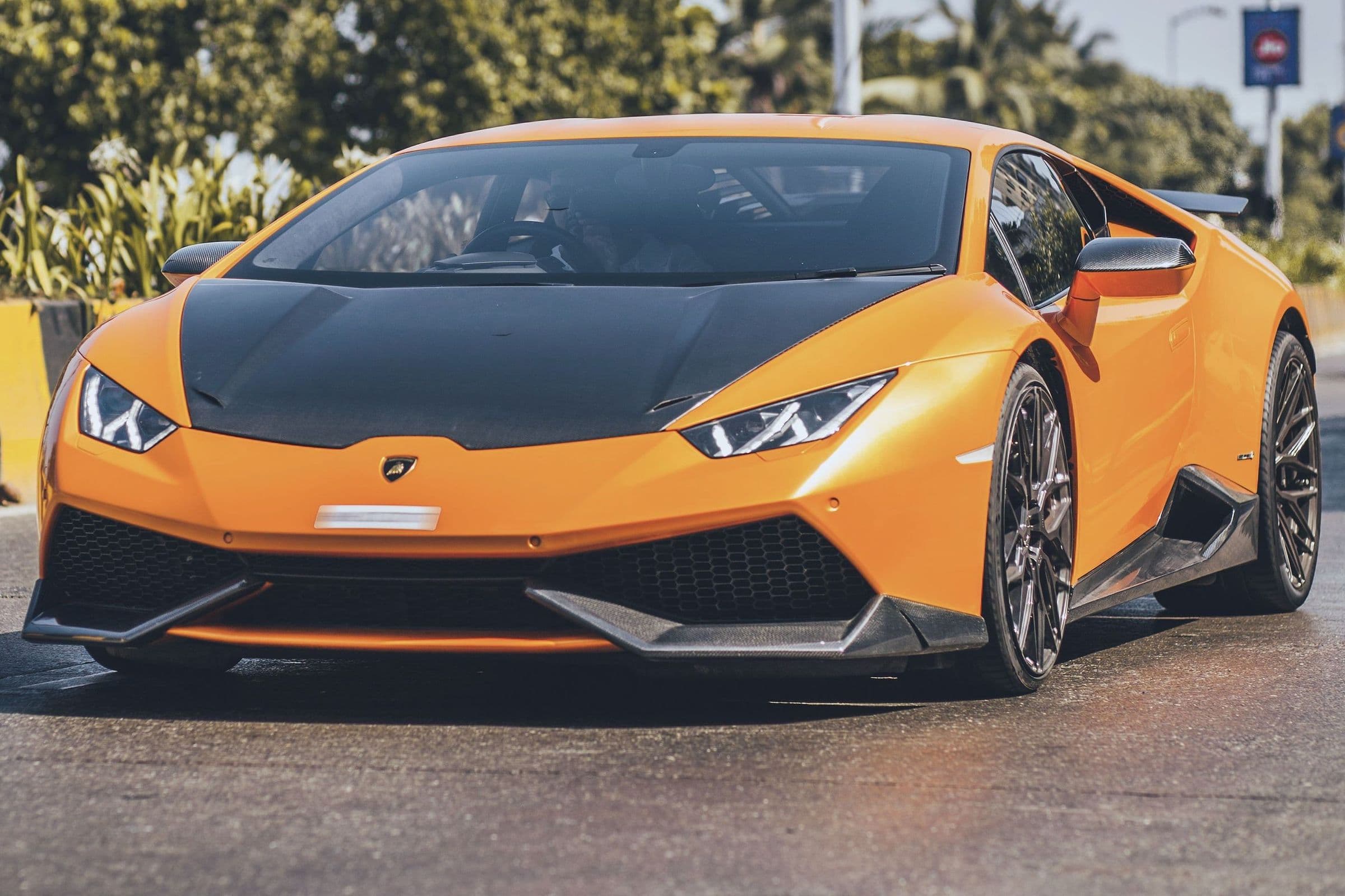 An orange Lamborghini Huracán with a carbon-fibre bonnet, front three-quarter.