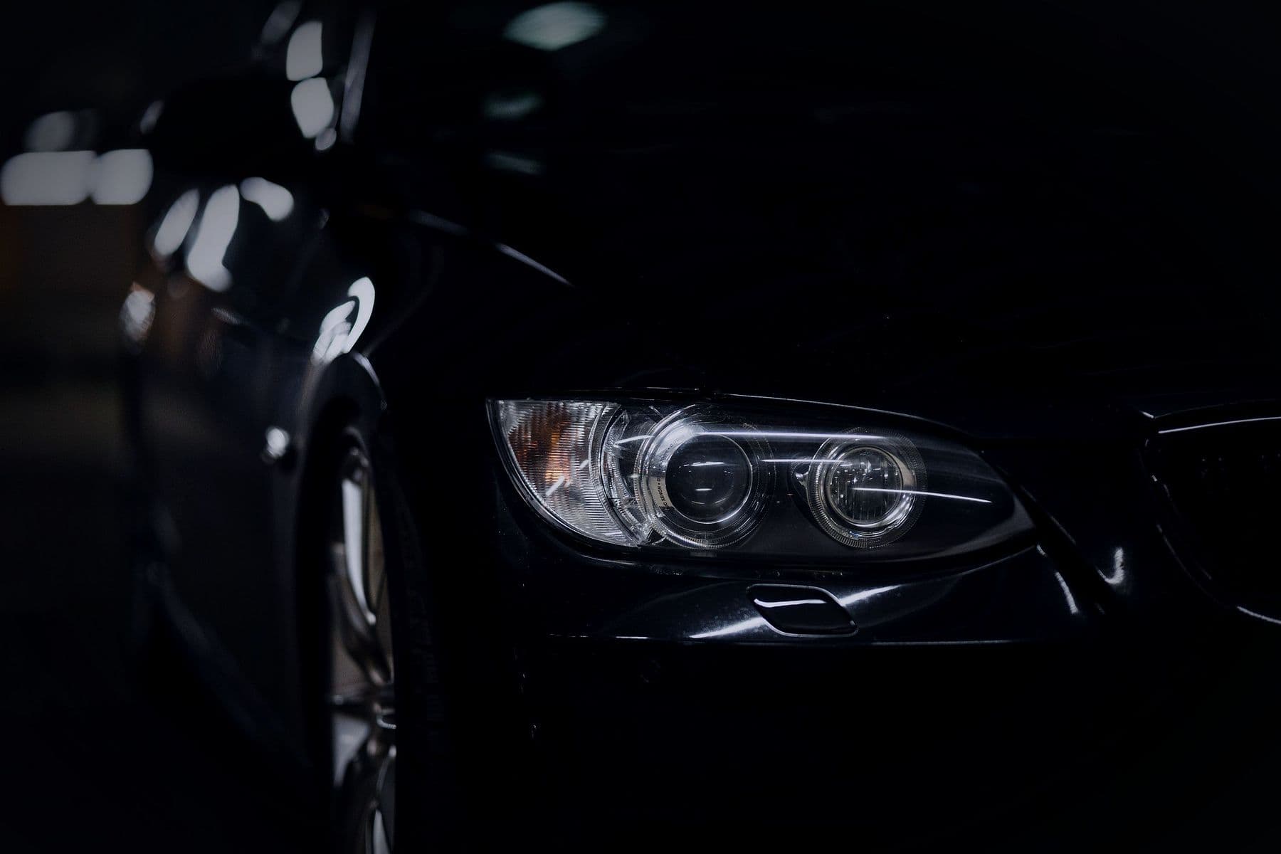 A headlamp emerging from darkness.